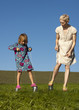 A mother and daughter playing outside on tin can stilts
