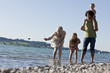 A family paddling in a lake skimming stones