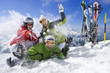 Skis in snow and family having snowball fight on mountain top