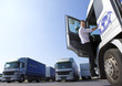 Truck driver climbing in to cab of semi-truck