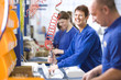 Foto: Portrait of smiling woman working on aluminium light fittings on production line in factory Portrait of smiling woman working on aluminium light fittings on production line in factory