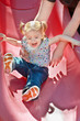 Happy smiling blonde toddler girl on playground slide Happy smiling blonde toddler girl on playground slide