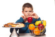 boy choosing a healthy apple snack over a dessert