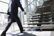 Rushing businessman walking towards office staircase