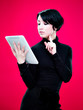Femme debout tenant une tablette tactile - fons rouge