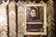 Clerk lifting gold frame in frame shop