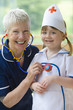 Smiling grandmother playing doctor and nurse with granddaughter