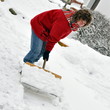 Frau beim Schnee räumen