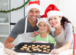 Happy woman with husband and daughter ith their biscuits ready