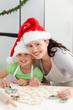 Beautiful mother and daughter cooking Christmas biscuits Beautiful mother and daughter cooking Christmas biscuits
