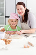 Portrait of a happy mother and daughter kneading a dough Portrait of a happy mother and daughter kneading a dough