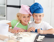 Portrait of two adorable children baking in the kitchen