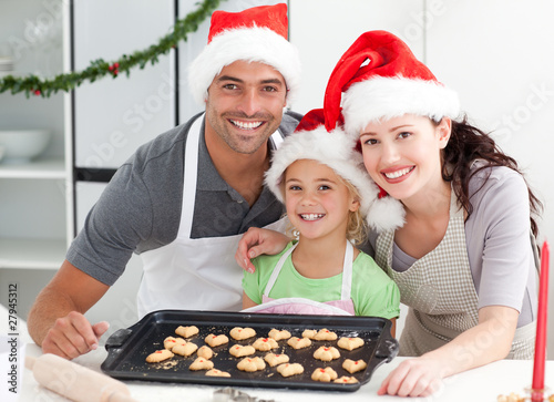 Photo: Happy woman with husband and daughter ith their biscuits ready Happy woman with husband and daughter ith their biscuits ready