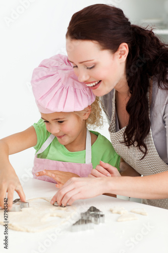 Photo: Happy mother and daughter cooking biscuits together Happy mother and daughter cooking biscuits together