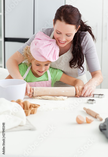 Photo: Beautiful mother and her cute daughter using a rolling pin Beautiful mother and her cute daughter using a rolling pin