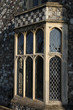 Stone lattice bay window in old wall with chequered pattern Stone lattice bay window in old wall with chequered pattern