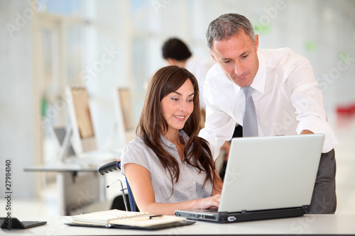 Photo: Manager and office worker in wheelchair Manager and office worker in wheelchair
