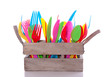 colorful plastic cutlery in a wooden crate isolated over white colorful plastic cutlery in a wooden crate isolated over white