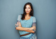 Earnest brunette standing against the wall