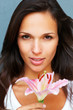 Brunette holding stargazer lily in front of her Brunette holding stargazer lily in front of her