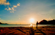 Sunset beach with a silhouette of boy and bicycle