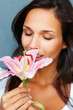 Brunette smelling stargazer lily with eyes closed Brunette smelling stargazer lily with eyes closed