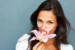 Brunette holding stargazer lily towards camera Brunette holding stargazer lily towards camera