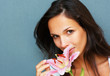 Brunette looking at camera while holding stargazer lily Brunette looking at camera while holding stargazer lily