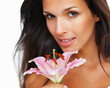 Brunette holding stargazer lily towards camera Brunette holding stargazer lily towards camera