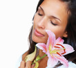 Brunette holding stargazer lily against cheek Brunette holding stargazer lily against cheek