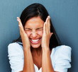 Woman cringing with hands against cheeks