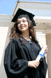 Young caucasian smiling student in gown near the university Young caucasian smiling student in gown near the university
