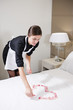 Maid Preparing Bed For Honeymooners