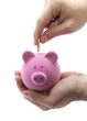 Putting coin into the piggy bank Putting coin into the piggy bank