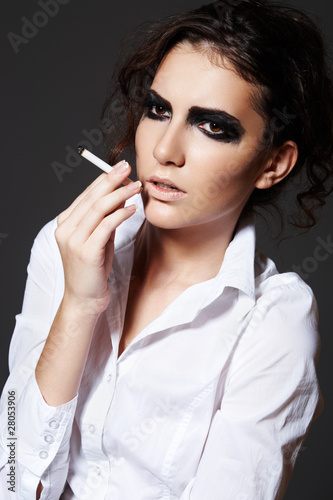 Photo: Beautiful woman model smoking a cigarette. Rock make-up Beautiful woman model smoking a cigarette. Rock make-up
