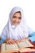Little girl reads Koran and smiles