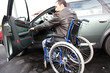 Young man in wheelchair getting in his car