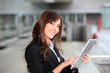 Businesswoman standing outside with electronic tab