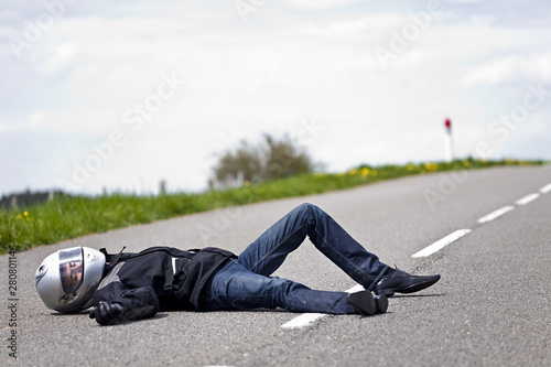 Photo: motard accidenté allongé sur route après accident de moto motard accidenté allongé sur route après accident de moto