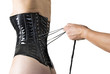 Male hands lacing back of a corset.