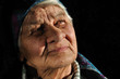 The sad, old woman, looking away, isolated black The sad, old woman, looking away, isolated black