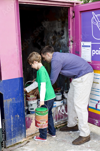 Photo: A father and son recycling tins of paint A father and son recycling tins of paint