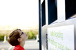 A young boy looking at a recycling container for textiles