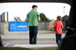 A son helping his father recycle cardboard boxes, rear view