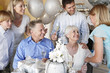 Foto: Grandmother smiling at granddaughter at party with whole family Grandmother smiling at granddaughter at party with whole family
