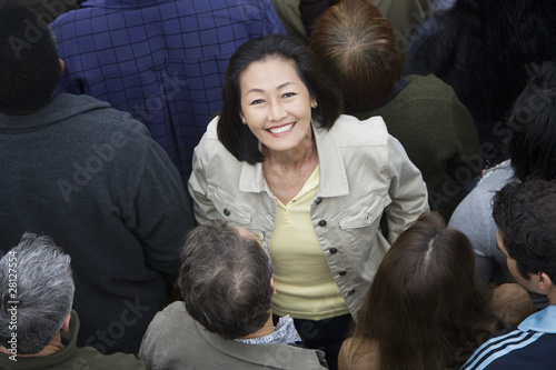 Photo: Woman standing among crowd Woman standing among crowd