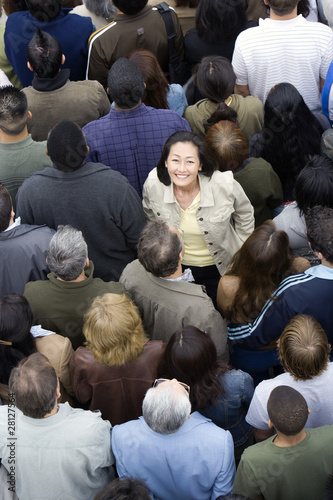 Photo: Woman standing among crowd Woman standing among crowd