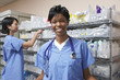 Photo: Portrait of female doctor, nurse standing by shelves with medical supplies in background Portrait of female doctor, nurse standing by shelves with medical supplies in background