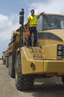 Photo: Worker standing on truck at landfill site, portrait Worker standing on truck at landfill site, portrait