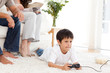 Cute boy playing video game lying on the floor at home